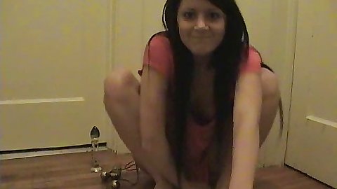 Chick sits in a corner inserting a vibrator in